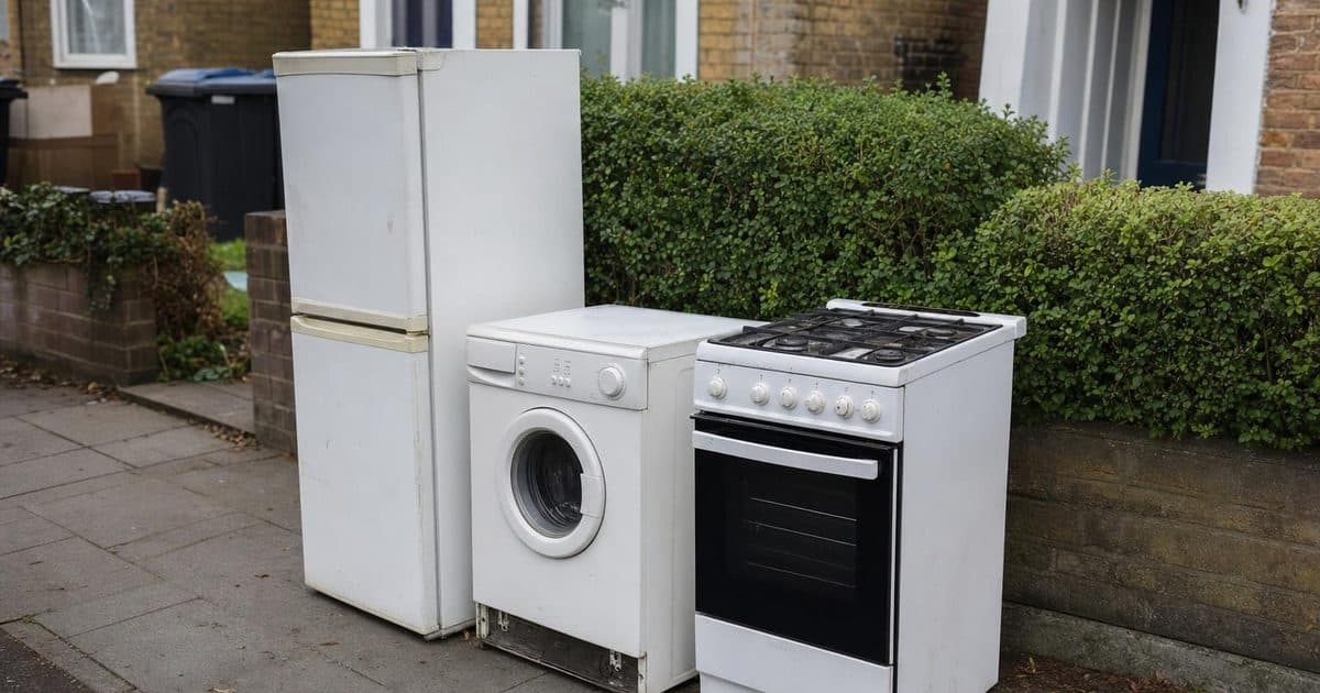 Old white goods including a fridge and washing machine ready for disposal in Bromley